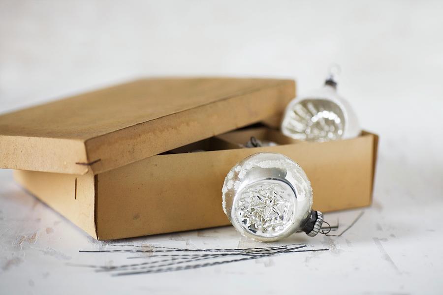 Vintage-style Christmas Baubles And Old Cardboard Box Photograph by Alicja Koll
