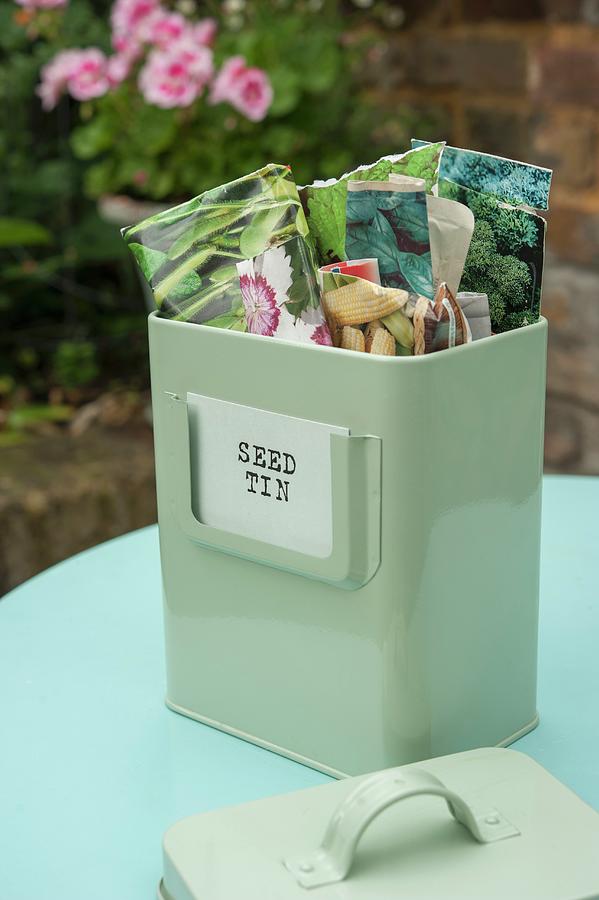 Vintage-style Metal Tin Of Seed Packets On Table In Garden Photograph by Linda Burgess