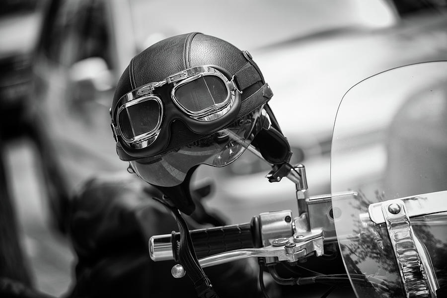 Vintage Style Motorbike Helmet With Goggles On The Motorcycle Handlebar. In Black And White Photograph