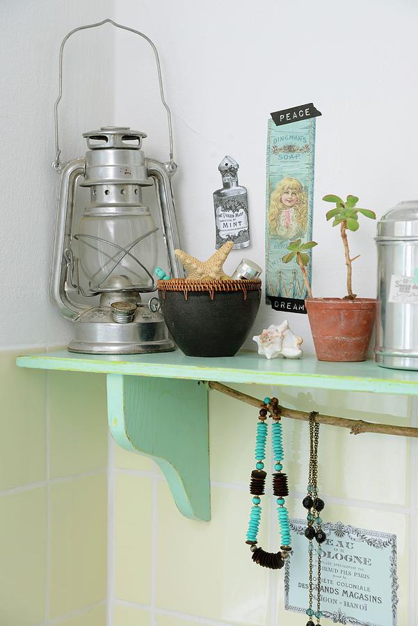 Vintage-style Ornaments And Storm Lamp On Mint-green Bracket Shelf Photograph by Revier 51