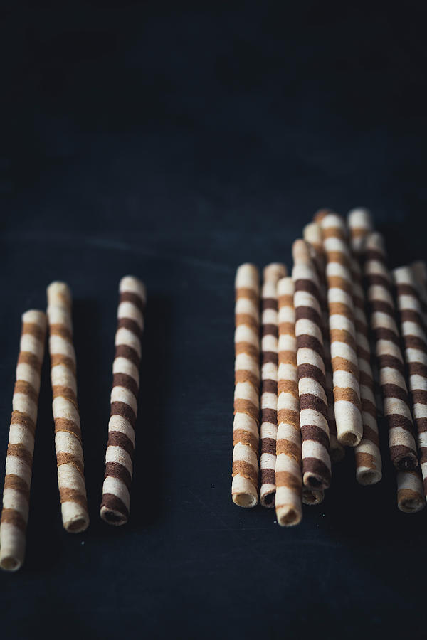 Waffer Roll Cookies On A Dark Surface Photograph by Malgorzata Laniak