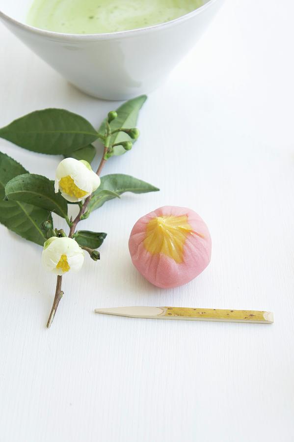Wagashi Plum ume Next To A Flowering Sprig Of Tea Leaves And A Bowl Of Matcha Tea Photograph by Martina Schindler
