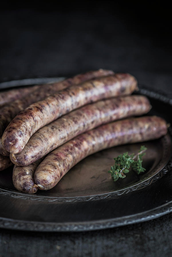 Wagyu Bratwurst On A Serving Dish With A Thyme Sprig Photograph by M. Nlke