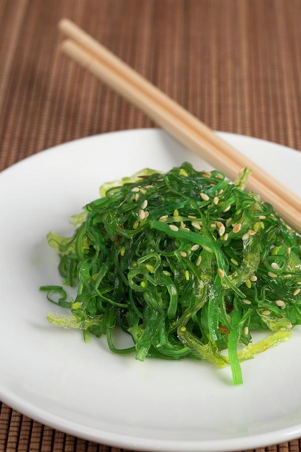 Wakame Salad With Sesame Seeds On A Wooden Mat Photograph by Jan Wischnewski