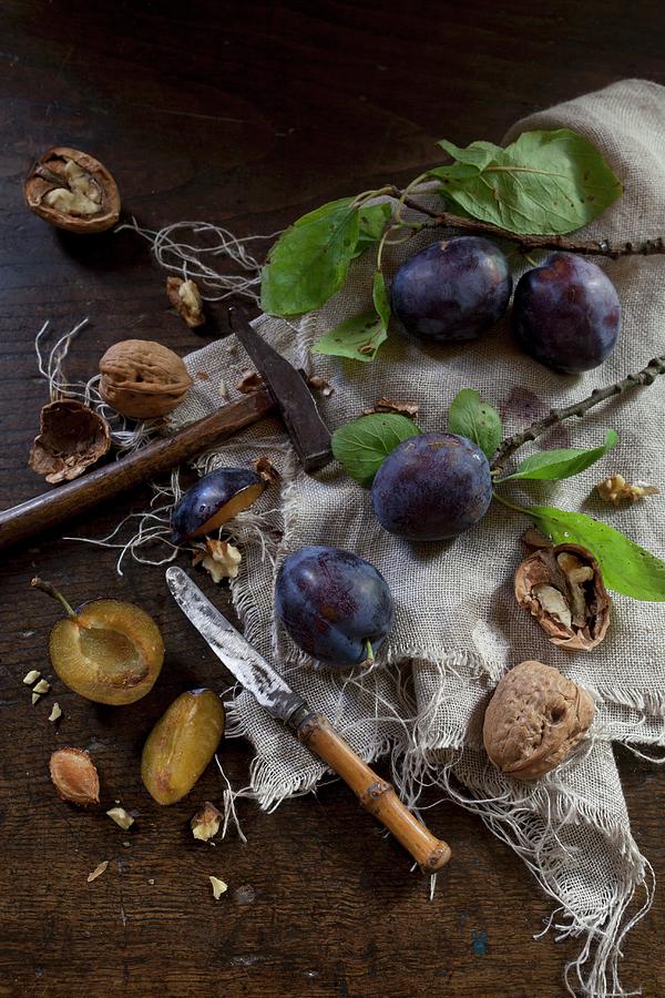 Walnuts And Plums With Leaves Rustic Wooden Table With A Knife And A Hammer Photograph by Zaira Lavinia Zarotti
