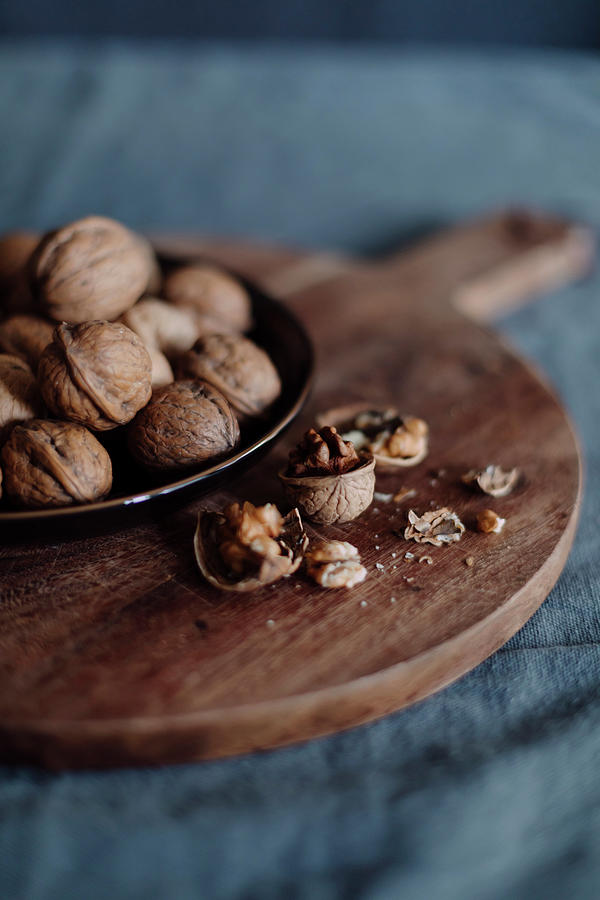 Walnuts In The Shells And Opened On A Wooden Board Photograph by Pia Simon