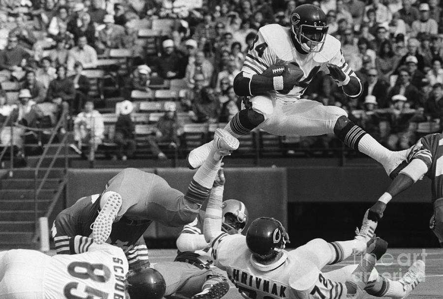 Walter Payton Jumps Over Gary Hrivnak Photograph by Bettmann Walter Payton Jumps Over Gary Hrivnak Photograph by Bettmann