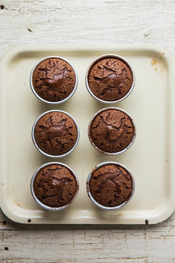 Warm Fondants Au Chocolat In Baking Tins On A Baking Tray Photograph by Artfeeder