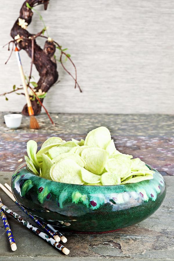 Wasabi Flavoured Crisps In A Ceramic Bowl Photograph by Atelier Hmmerle