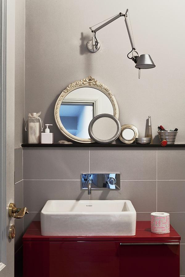 Washstand With Countertop Trough On Red Base Unit Below Designer Wall Lamp And Collection Of Round Mirrors Photograph by Fabio Lombrici