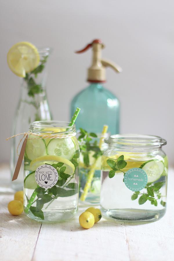 Water Aromatised With Cucumber, Lemon And Herbs In Glass Jars Photograph by Sylvia E.k Photography