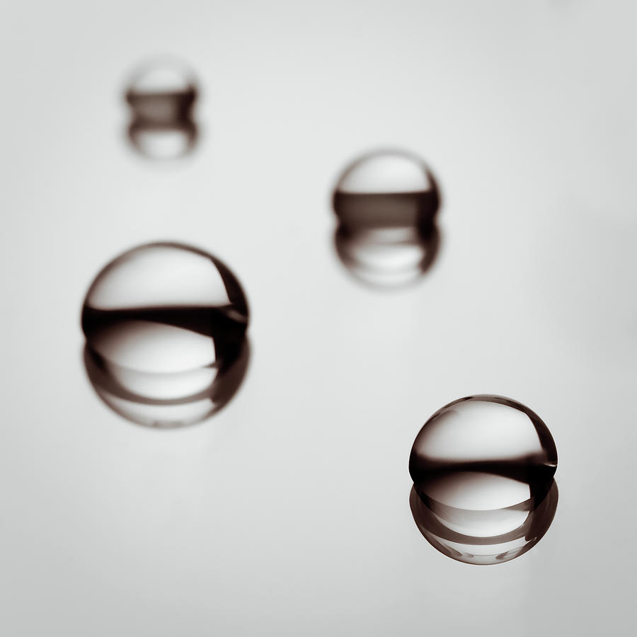 Water Droplets On A Reflective Surface Photograph by Vilhjalmur Ingi Vilhjalmsson