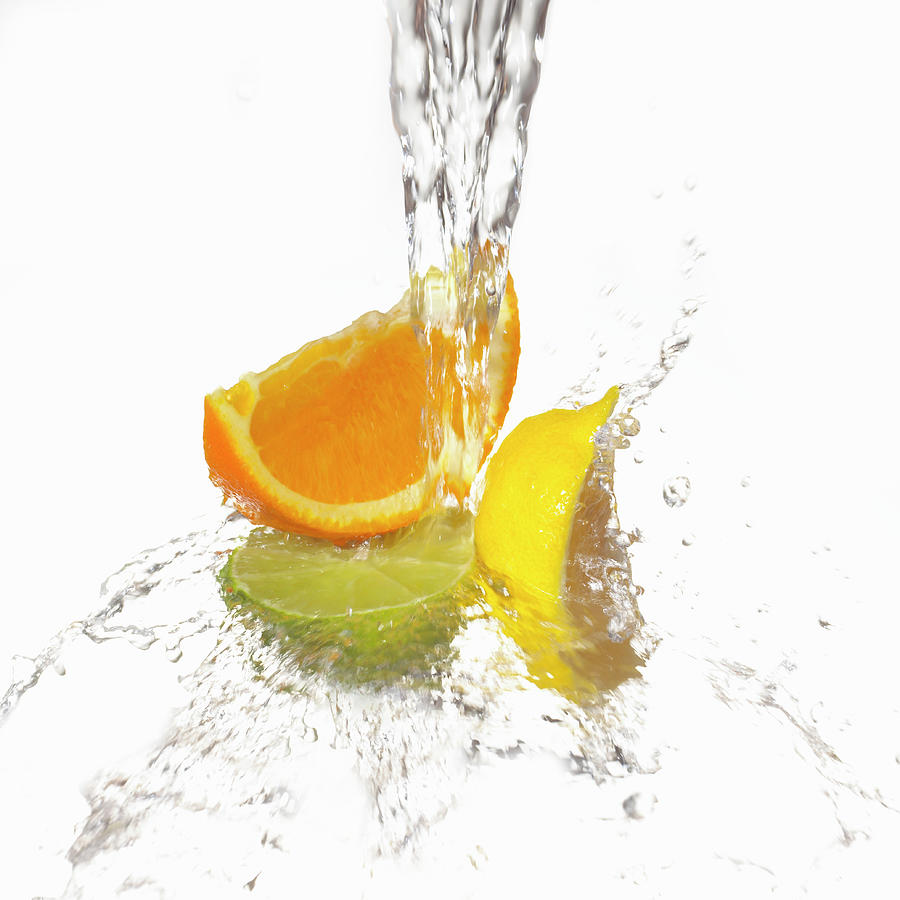 Water Splashing On Citrus Slices Photograph by Annabelle Breakey