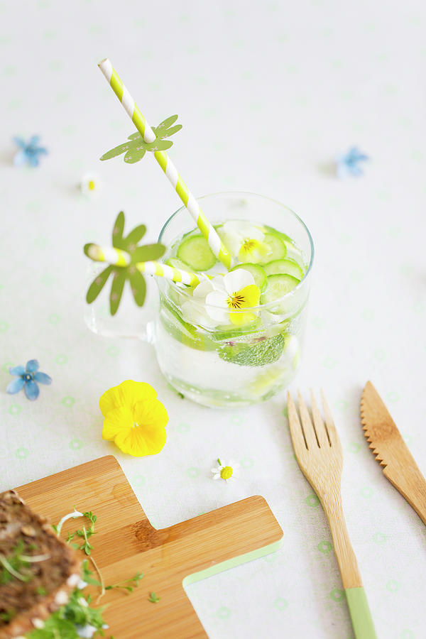 Water With Cucumber, Edible Violas And Drinking Straws With Paper Decorations Photograph by Iris Wolf