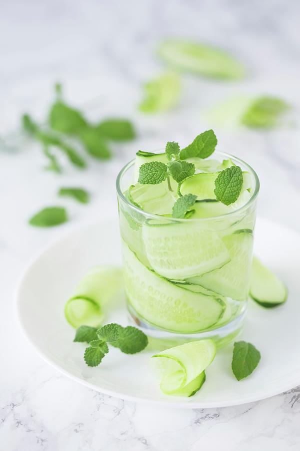 Water With Cucumber Strips, Fresh Mint And Ice Cubes Photograph by Malgorzata Laniak