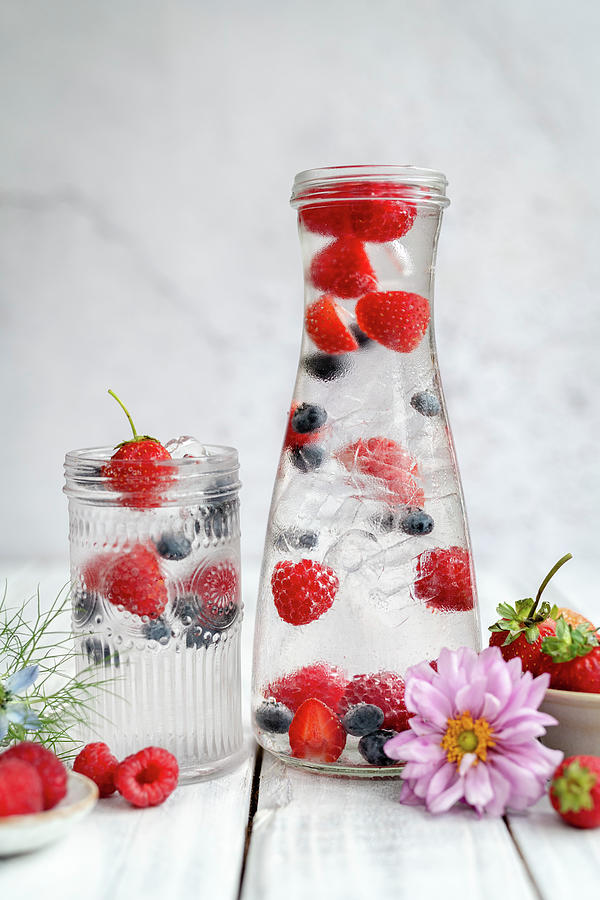 Water With Fresh Berries And Ice Cubes Photograph by Lucy Parissi