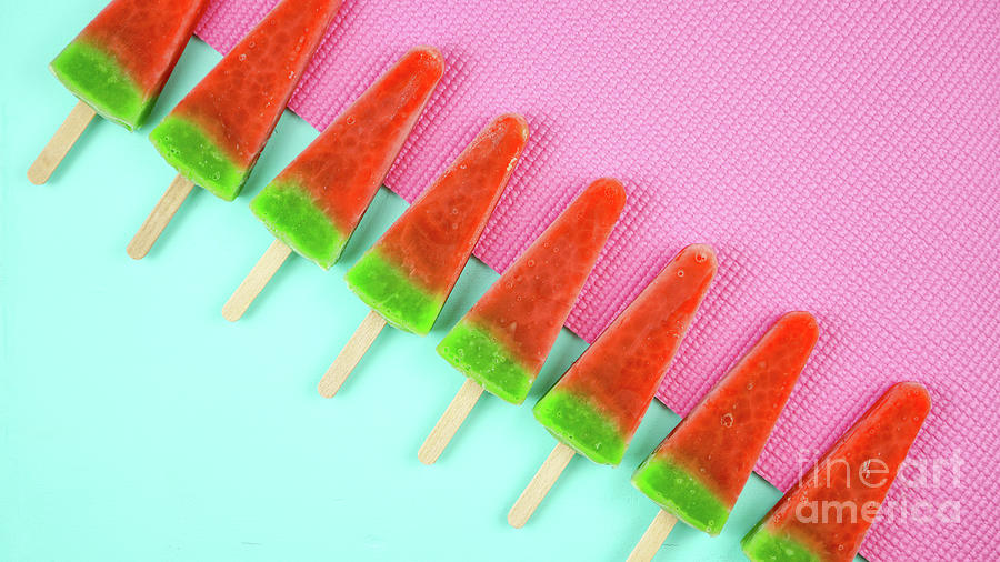 Watermelon flavored summer ice cream popsicles on pink and blue background. Photograph by Milleflore Images