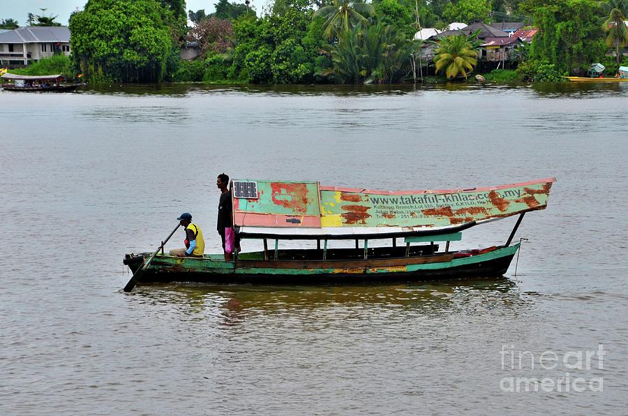 Weathered boat with sailor and passenger and solar panel crosses Sarawak River Kuching Malaysia Photograph by Imran Ahmed
