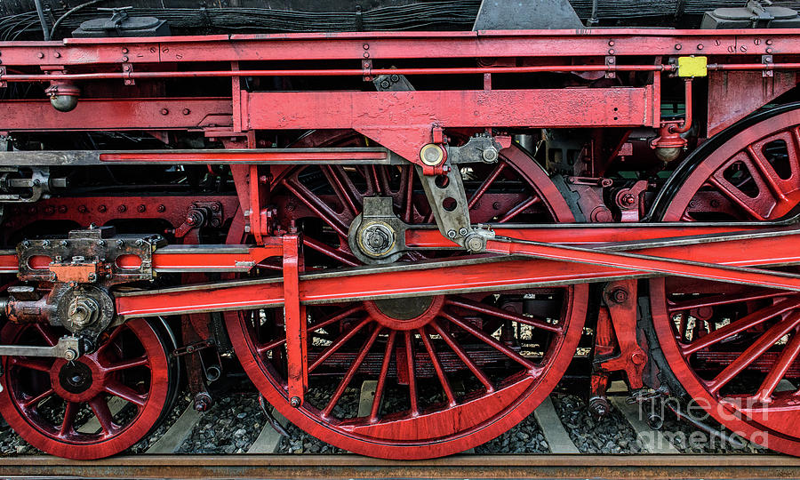 Well-kept steam locomotive with shiny red wheels stands on rail-road track. Photograph by Ulrich Wende