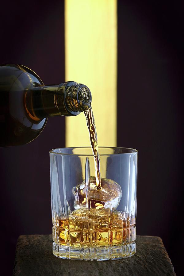Whisky Being Poured Into A Glass Of Ice Photograph by Jalag / Michael Bernhardi