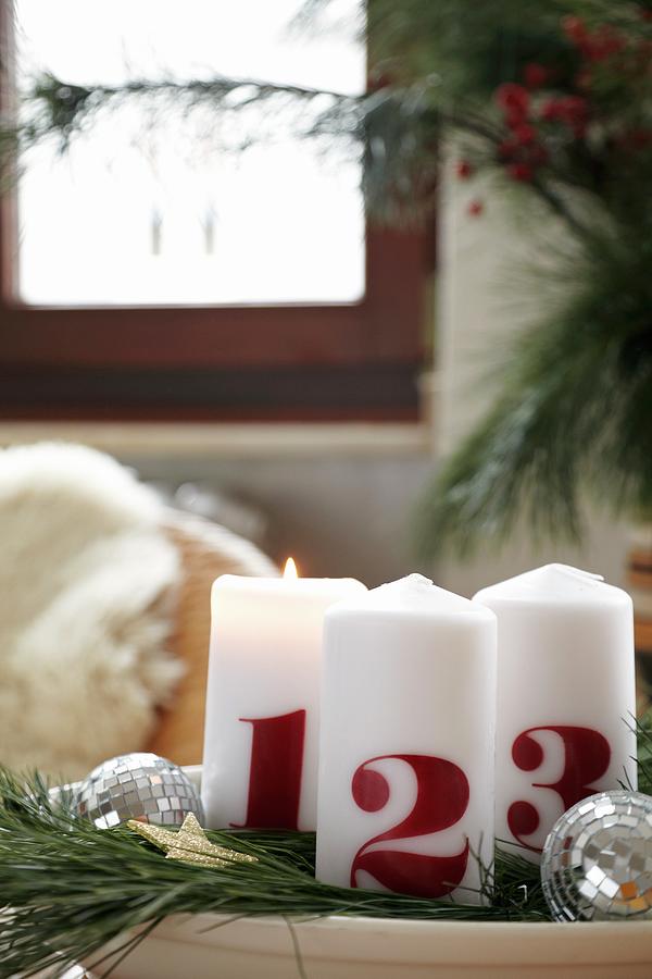 White Advent Candles Printed With The Numbers 1, 2, 3 On Plate Decorated With Fir Branches And Disco Balls Photograph by Lioba Schneider Fotodesign