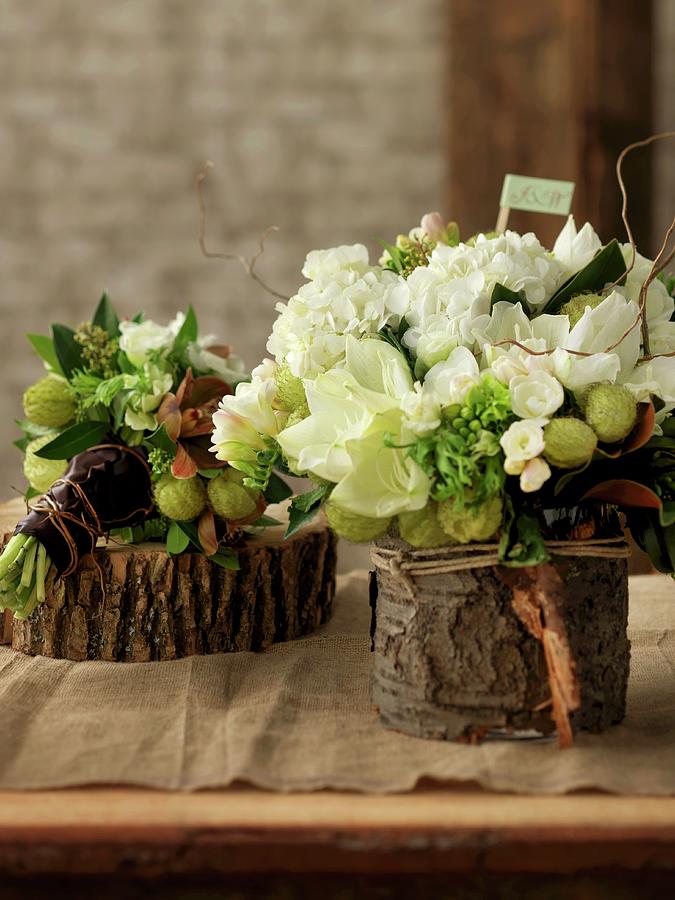 White And Green Flower Arrangements On Slices Of Tree Trunks Photograph by Jim Norton