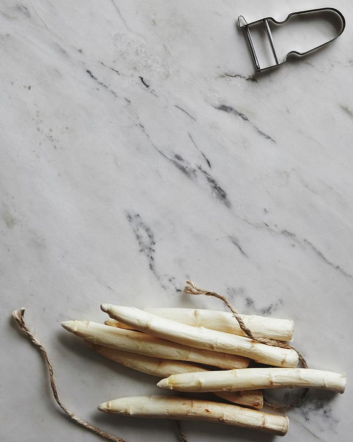 White Asparagus Spears, Kitchen Twine And A Peeler Photograph by Fanny Rdvik