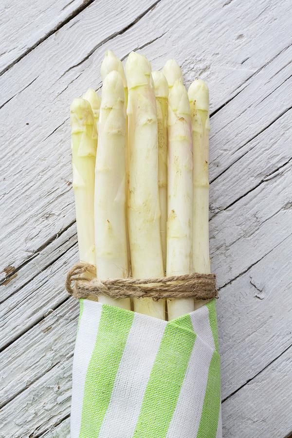 White Asparagus, Tied In A Bundle, In A Striped Cloth Photograph by Uwe Merkel