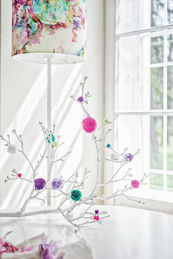 White Branches Decorated With Colourful Pompoms Decorating Table In Front Of Standard Lamp With Colourful Lampshade Photograph by Patsy&christian