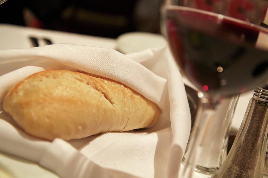 White Bread Wrapped In A Napkin And A Glass Of Red Wine Photograph by Brenda Spaude