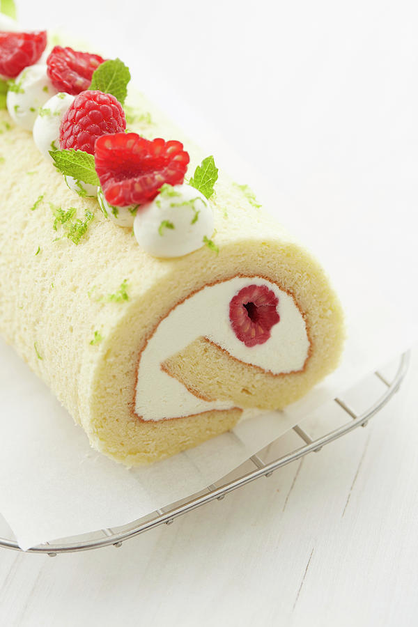 White Chocolate And Raspberry Rolled Sponge Cake Decorated With Raspberries, Lime Zests And Mint Photograph by Lukam