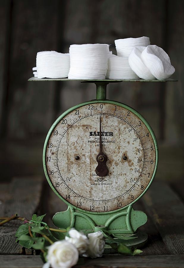 White Cotton Pads On An Old Pair Of Kitchen Scales Photograph by Emel Ernalbant