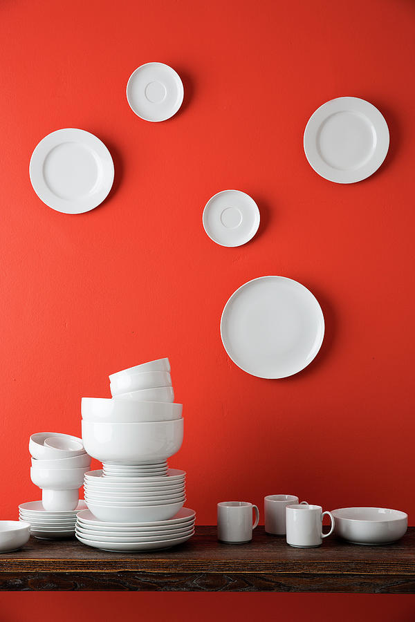 White Crockery On Table And White Plates On Red Wall Photograph by Roberto Rabe