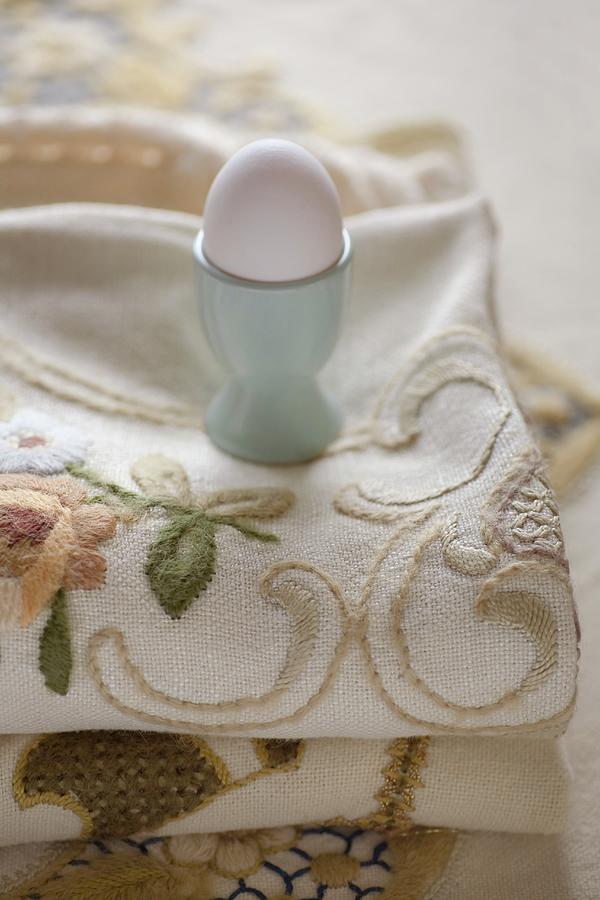 White Hens Egg In Turquoise Eggcup On Embroidered Tablecloth Photograph by Alicja Koll