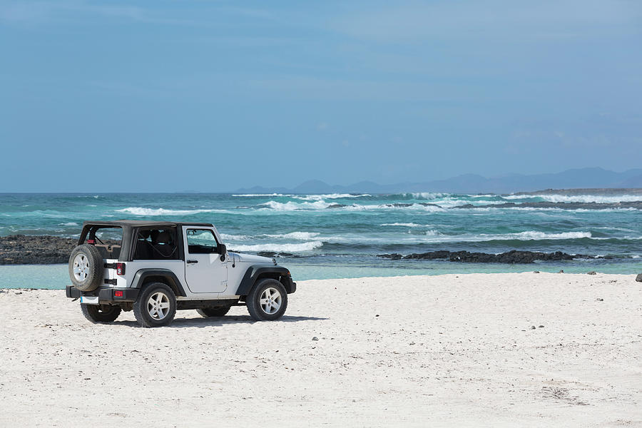 White Jeep 4x4 Parked Empty White Beach With Blue Ocean Background