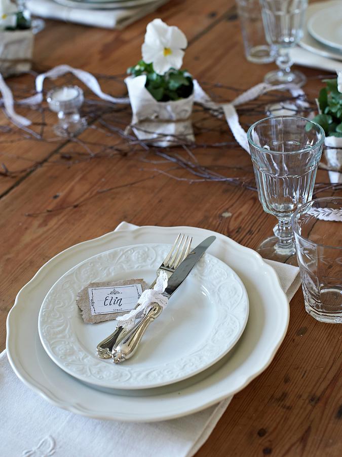 White Place Setting With Glasses And Violas On Rustic Wooden Table Photograph by Hannah Kompanik