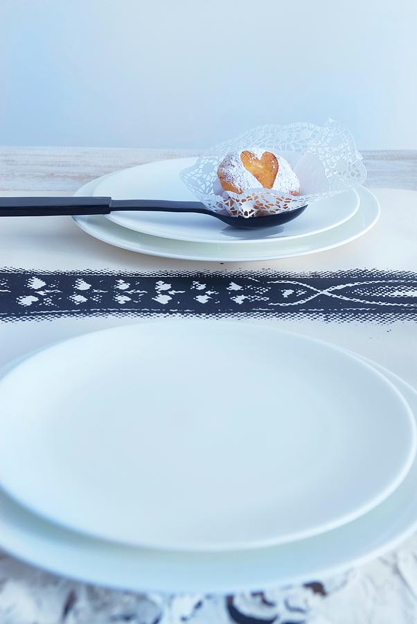 White Plate, Black Spoon With Biscuit On Doily And Printed Paper Table Mat Photograph by Matteo Manduzio