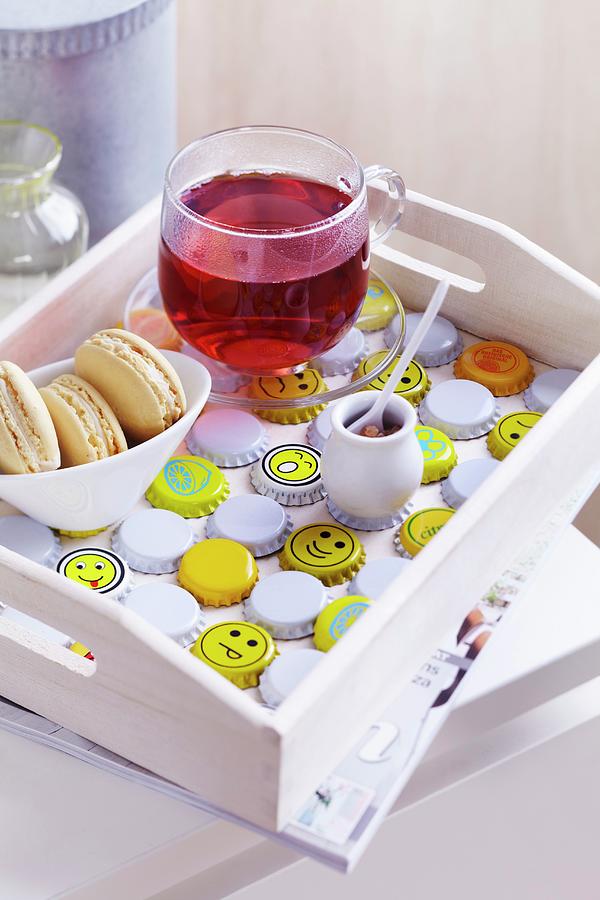 White Wooden Tray With Cup Of Fruit Tea And Dish Of Biscuits Arranged On Bottle Caps Painted White And Yellow With Smiley Faces Photograph by Franziska Taube