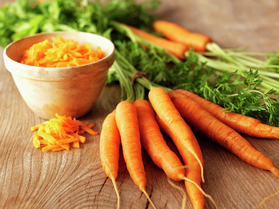Whole Organic Carrots And A Bowl Of Grated Carrot Photograph by Frank Adam