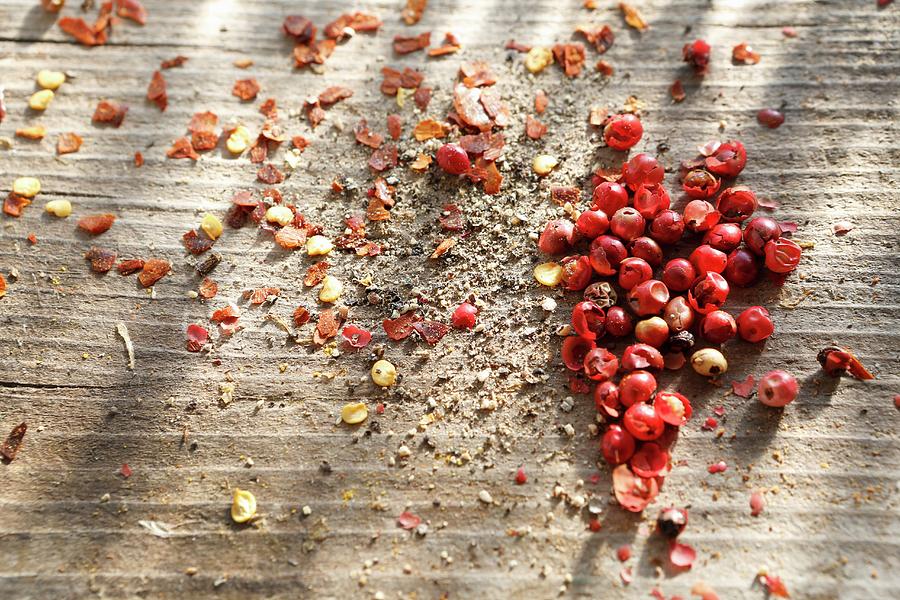 Whole Pink Peppercorns, Ground Black Pepper And Chilli Flakes Photograph by Viola Cajo