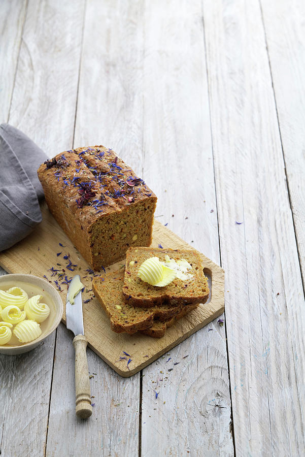 Wholemeal Spelt Bread, Sliced, With Curls Of Butter Photograph by Oliver Stockfood Studios / Brachat