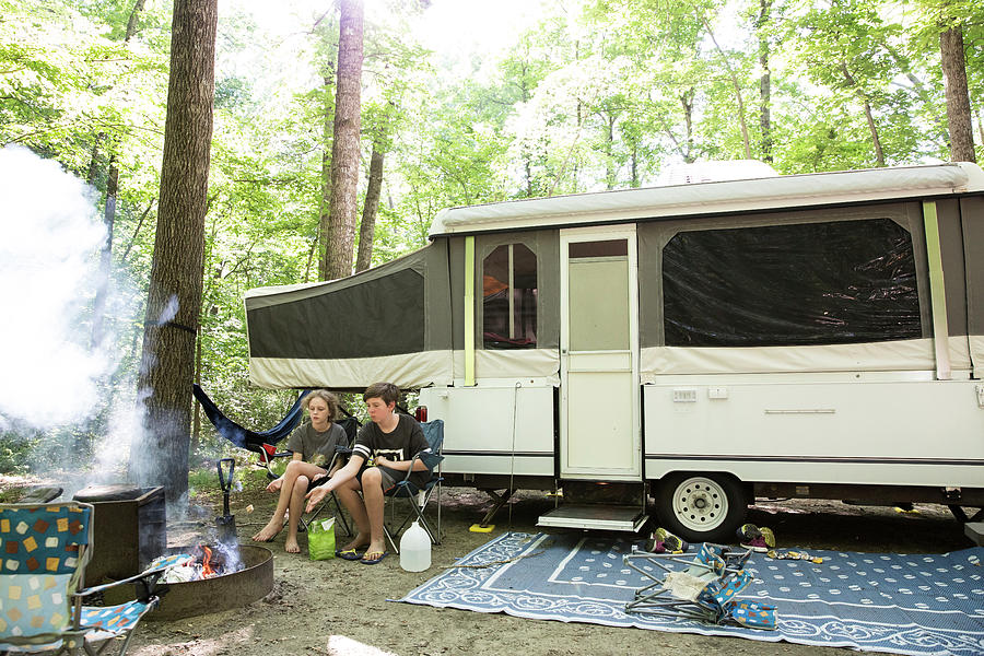Nature Photograph - Wide View Of Siblings Roasting Hot Dog Sitting In Front Of Tent Camper by Cavan Images