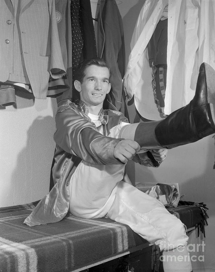 Willie Shoemaker Pulling On Riding Boots Photograph by Bettmann