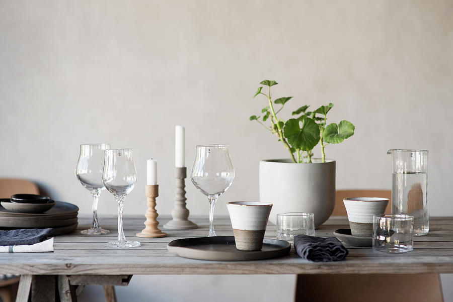 Wine Glasses, Beakers, Houseplant And Candles On Rustic Wooden Table Photograph by Magdalena Bjrnsdotter