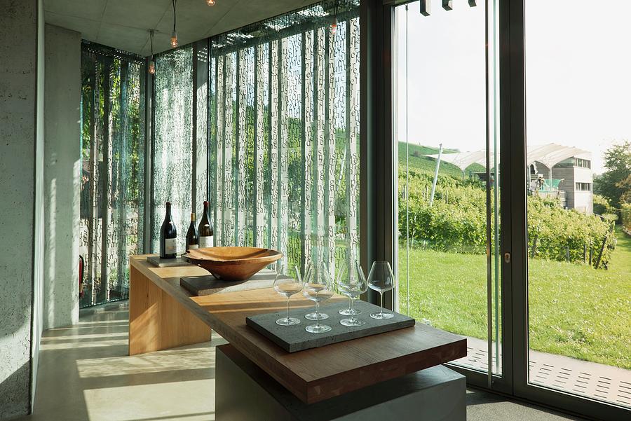 Wine Glasses On A Large Wooden Table In Front Of Floor-to-ceiling Windows In A Vinotheque; Weingut Am Stein, Wrzburg Photograph by Feig & Feig