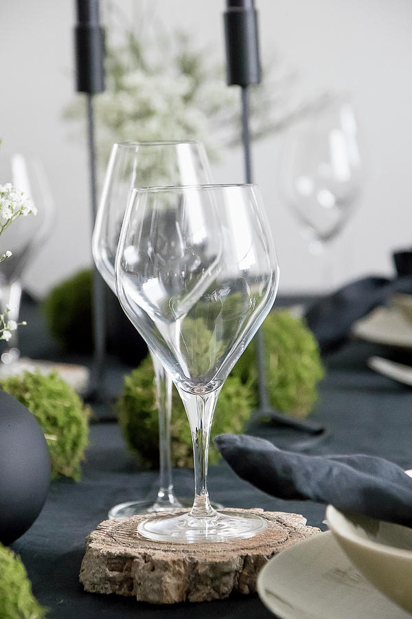 Wine Glasses On Wooden Coasters On Set Table Photograph by Astrid Algermissen