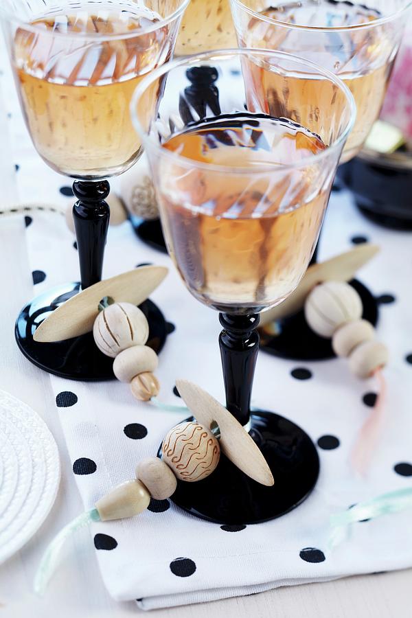Wine Glasses With Threaded Wooden Beads Tied Around Stems Photograph by Franziska Taube