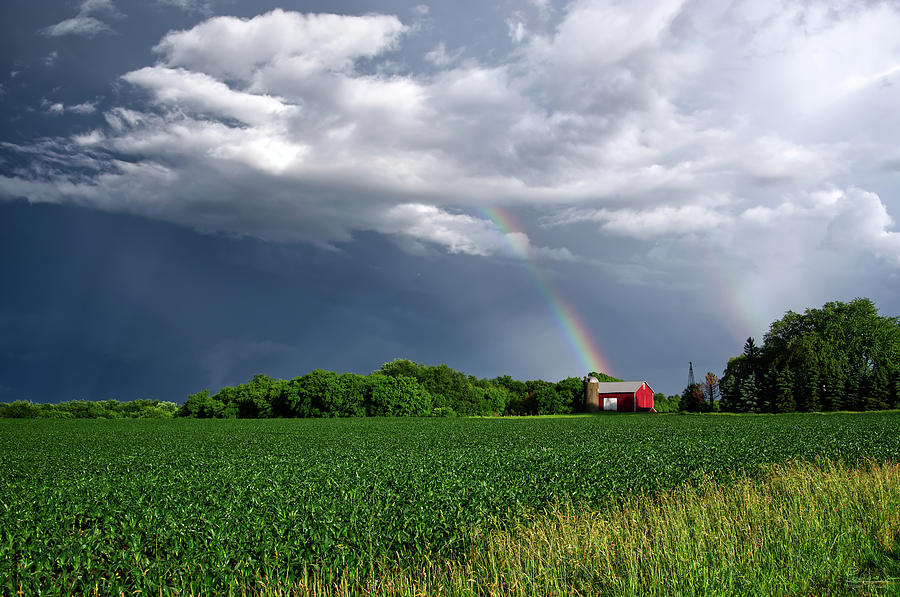 Wisconsin Gold - rural barn and silo at end of a spring rainbow with cornfield Photograph by Peter Herman
