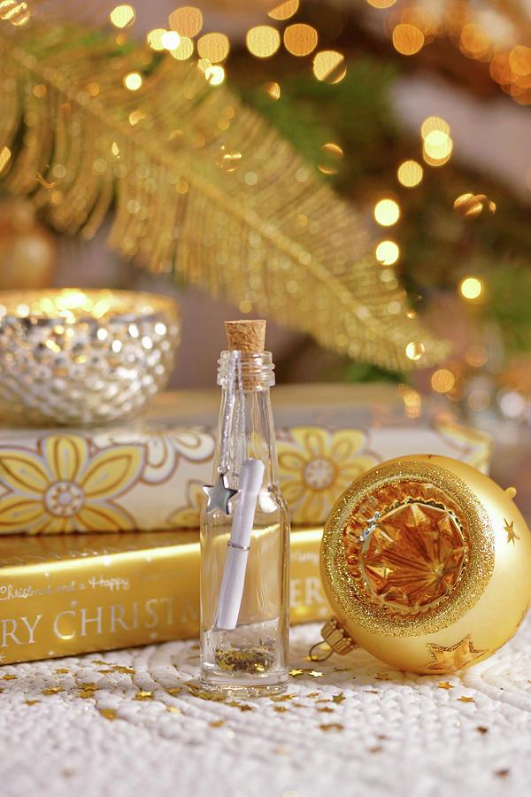 Wish List In Tiny Bottle Surrounded By Golden Christmas Decorations Photograph by Angelica Linnhoff