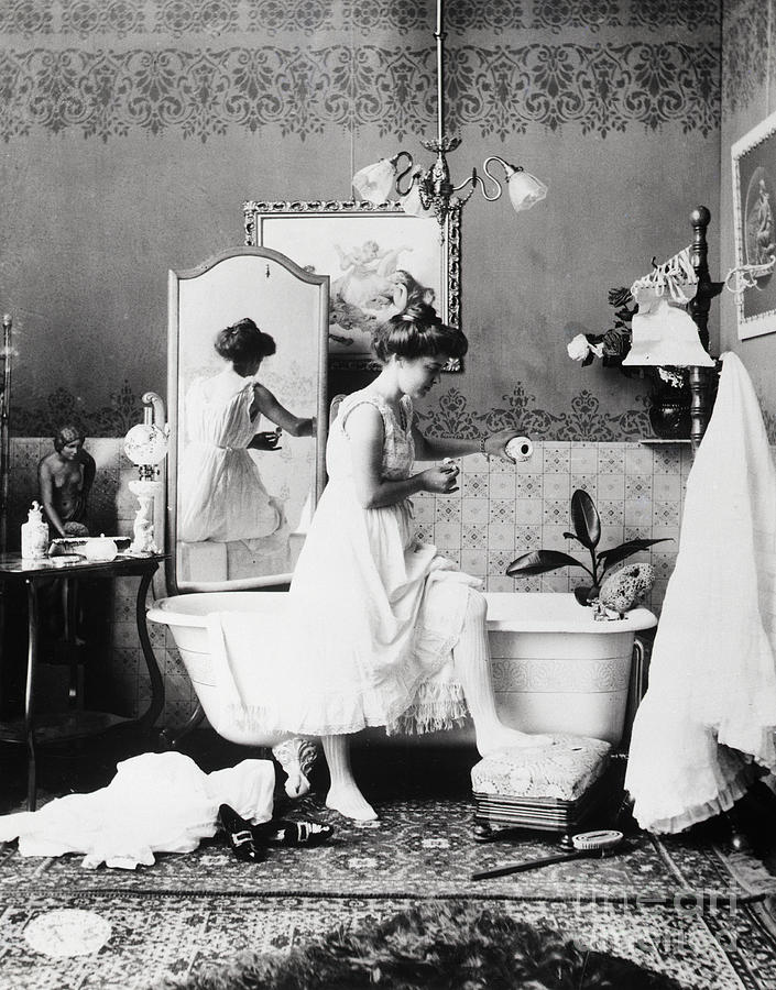 Woman Adding Bath Salts To Bath Water Photograph by Bettmann